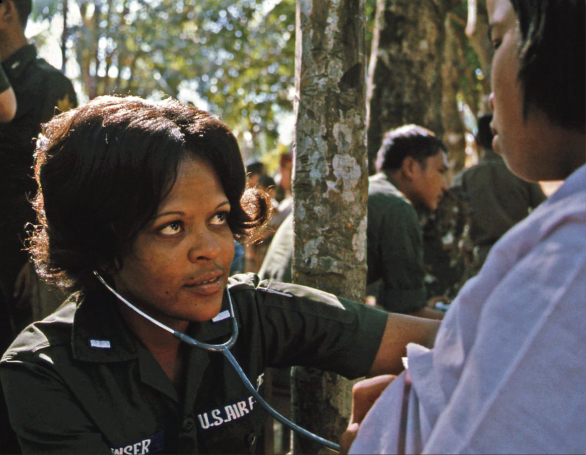 First Lieutenant Linda J. Bowser, an Air Force nurse with a MEDCAP team, examines a Thai girl, Bong Son Village, Thailand, January 10, 1974. 