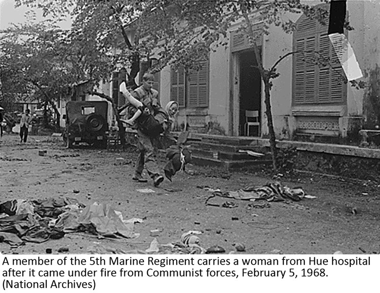 A member of the 5th Marine Regiment carries a woman from Hue hospital after it came under fire from Communist forces, February 5, 1968. (National Archives)