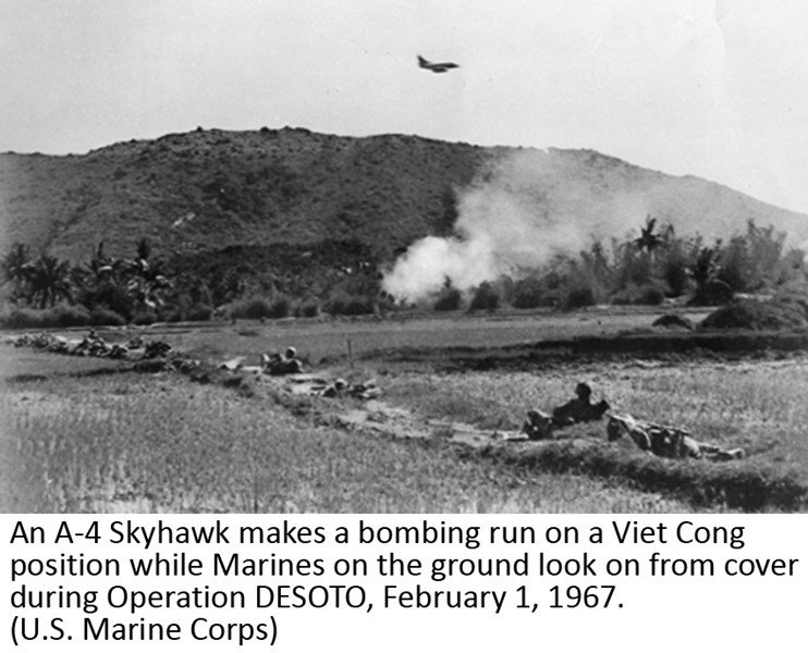 An A-4 Skyhawk makes a bombing run on a Viet Cong position while Marines on the ground look on from cover during Operation DESOTO, February 1, 1967 (U.S. Marine Corps)