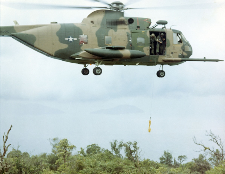 Equipped with a powerful external winch, the HH-3 Jolly Green Giant could extract a downed pilot without landing. Here an aircrew practices lowering a jungle penetrator. (U.S. Air Force)