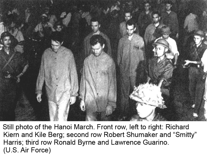 Still photo of the Hanoi March. Front row, left to right: Richard Kiern and Kile Berg; second row Robert Shumaker and “Smitty” Harris; third row Ronald Byrne and Lawrence Guarino. (U.S. Air Force)