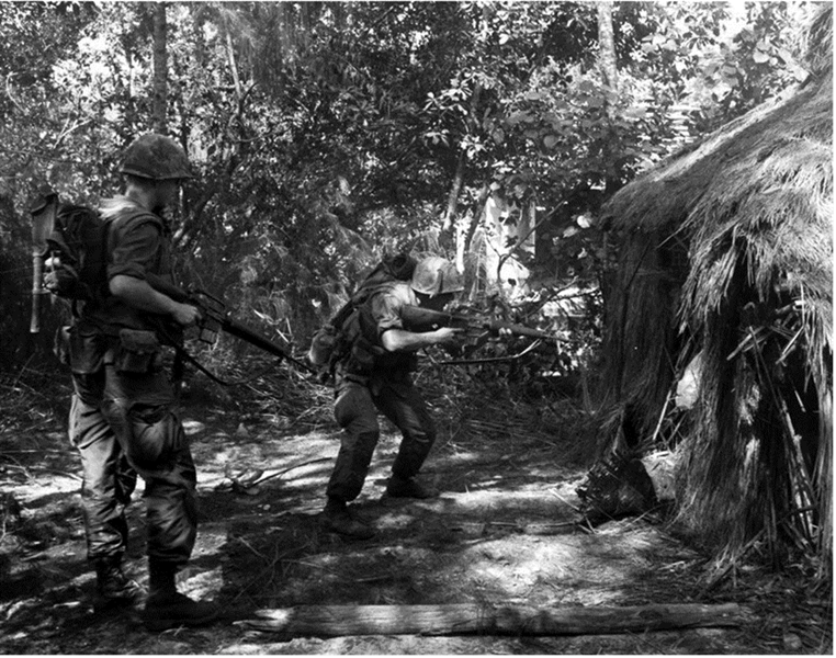 Photo of Marines of Company K, 3d Battalion, 1st Marines as they search a hut during Operation BADGER TOOTH (USMC)