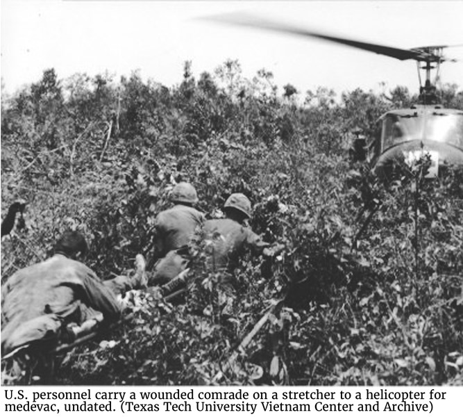 U.S. personnel carry a wounded comrade on a stretcher to a helicopter for medevac, undated. (Texas Tech University Vietnam Center and Archive)