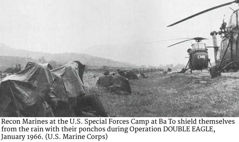 Recon Marines at the U.S. Special Forces Camp at Ba To shield themselves from the rain with their ponchos during Operation DOUBLE EAGLE, January 1966. (U.S. Marine Corps)