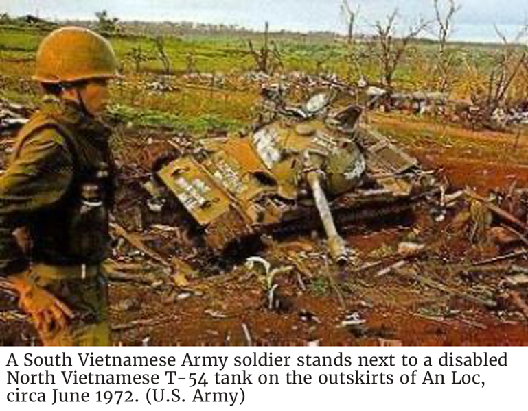 A South Vietnamese Army soldier stands next to a disabled North Vietnamese T-54 tank on the outskirts of An Loc, circa June 1972. (U.S. Army)