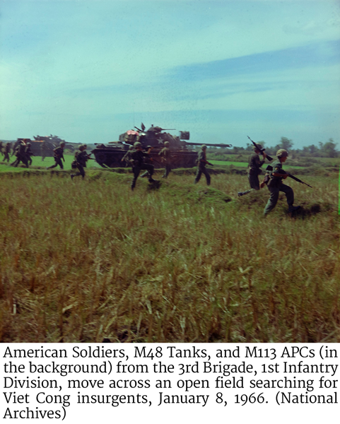 American Soldiers, M48 Tanks, and M113 APCs (in the background) from the 3rd Brigade, 1st Infantry Division, move across an open field