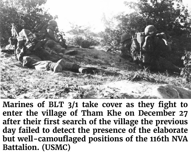 Photo of Marines of BLT 3/1 taking cover as they fight to enter the village of Tham Khe on December 27 after their first search of the village the previous day failed to detect the presence of the elaborate but well-camouflaged positions of the 116th NVA Battalion. (USMC)