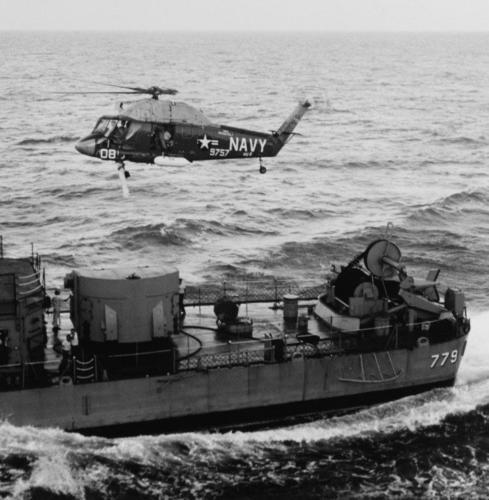 A Navy UH-2 Seasprite picks up a crewmember from the destroyer USS Douglas H. Fox for transportation back to the aircraft carrier USS Franklin D. Roosevelt, August 12, 1964.