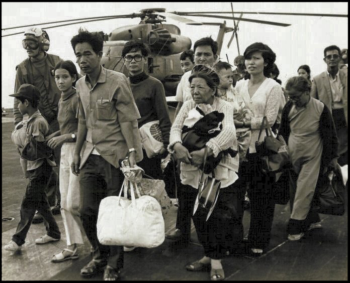South Vietnamese refugees walk across the deck of an American vessel after evacuating from Saigon, April 29, 1975. 