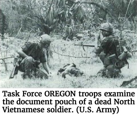 Photo of Task Force OREGON troops examining the document pouch of a dead North Vietnamese soldier. (U.S. Army)